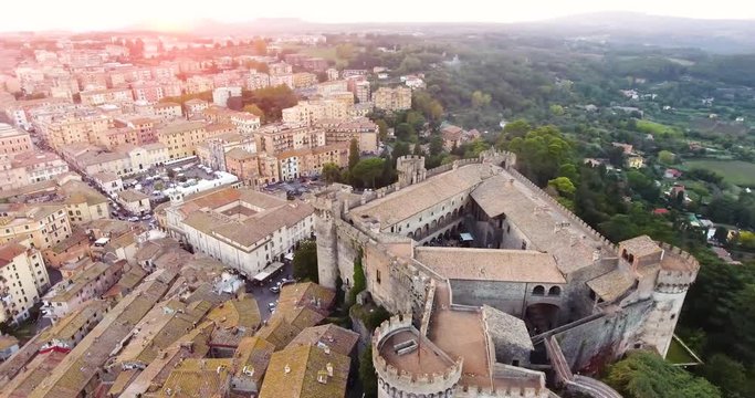 Aerial, orbit, drone shot overlooking the Castello Orsini-Odescalchi castle and the Bracciano town, sunny evening, in Lazio, Italy