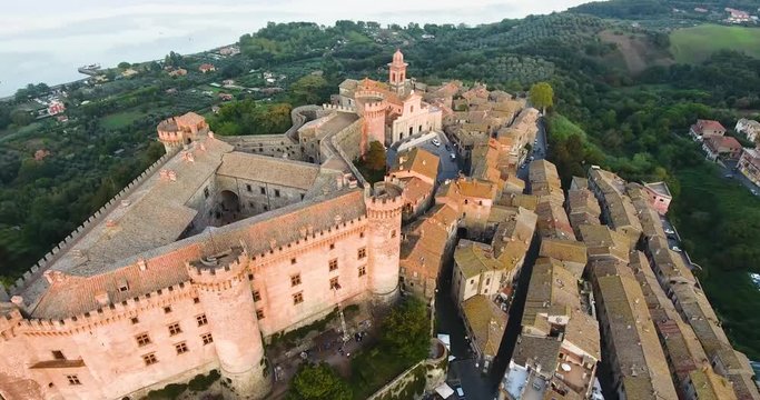 Aerial, rising, drone shot away from the Castello Orsini-Odescalchi castle, during sunset, in Bracciano, Lazio, Italy
