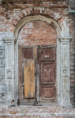 Fototapeta na wymiar Old wooden door in a destroyed brick building