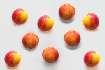 Peaches isolated on a white background are arranged in a pattern. Fruit concept, backgrounds for fruit stores or peach oils, drawings for tablecloths and fruit shower gels.