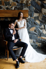 Obraz premium Stylish bride and groom posing in hotel room. Happy luxury wedding couple embracing. Romantic passionate sensual moment. Woman and man together