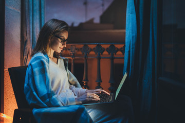 Home Office Late At Night, Young female professional copywritter in chair working at home, businesswoman working at night in homewear and eyeglasses using laptop computer reading email from client