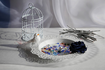 Composition still life in light colors is symbol of fragility of life. White bird, a cage,...