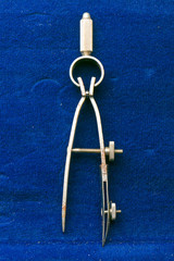 Antique drafting deviders on blue felt