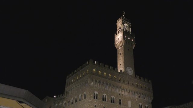 Palazzo Vecchio tower in Piazza Signoria, Italian city of Florence. Night shot. Zoom out. Warm winter night. 