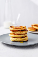 Pancakes. Stack of pancakes with honey on a gray background. Homemade breakfast