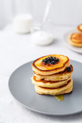 Pancakes. Stack of pancakes with honey on a gray background. Homemade breakfast