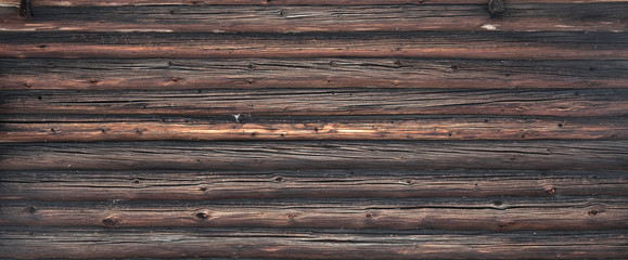 Brown old log wall. Wooden decrepit texture