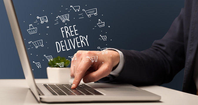 Businessman working on laptop with FREE DELIVERY inscription, online shopping concept