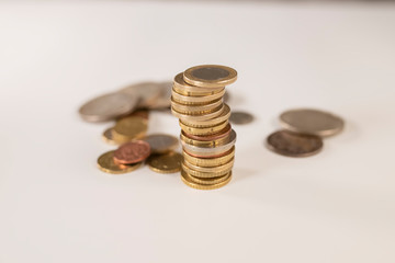 pile coin in the front and coins in the background out of focus