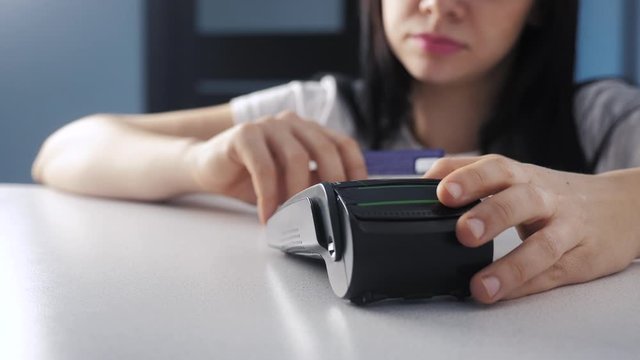 Payment by credit card, purchase and sale of goods and services. Credit card lifestyle in the store. girl pays on the card reader online shopping concept
