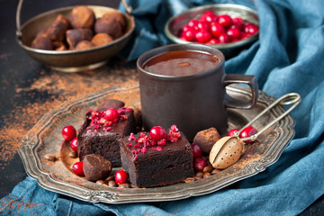 Still life with chocolate brownie and cocoa mug on dark table