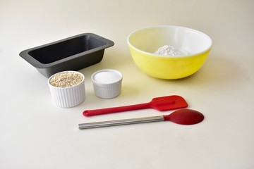 Baking ingredients with mixing bowls and kitchen utensils for making pastries and cookies
