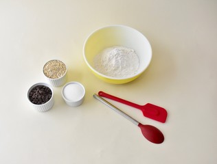 Baking ingredients with mixing bowls and kitchen utensils for making pastries and cookies