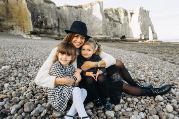 A beautiful young family on the sandy shore of the ocean relaxing and have a fun