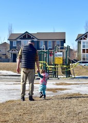 Disappointed Child and Father at edge of locked down playground during emergency measures