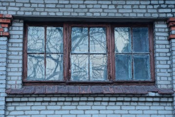 Fototapeta na wymiar one old brown window on a gray brick wall of a building