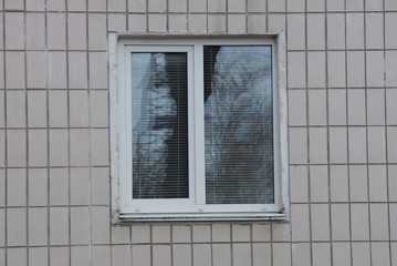 one large plastic white window on the wall with gray tiles