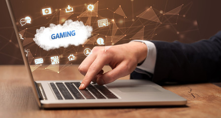 Businessman working on laptop with GAMING inscription, modern technology concept