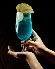 blue cocktail with apple slices on top