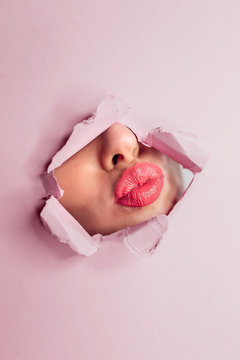 Girl Pouting Lips Through Hole In Pink Paper. Makeup, Beauty