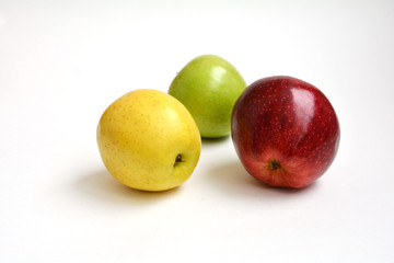Три разноцветных яблока красное зеленое желтое на белом фоне
