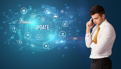 Businessman thinking in front of technology related icons and UPDATE inscription, modern technology concept