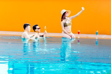 Group of friends taking selfie photo in poolside