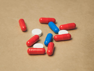 pile of red and blue pills on a beige background