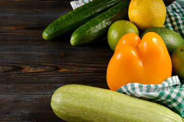 zucchini, cucumber, avocado, lemon, lime, pepper, lemon, towel on a wooden , fresh green and yellow vegetables and citrus,