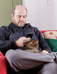 man in house confinement, looking al smartphone. quarantine for the prevention of covid-19