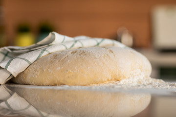 Yeast dough in flour lies on a stone table in the kitchen