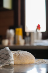 Yeast dough in flour lies on a stone table in the kitchen