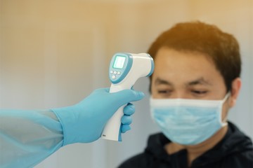 Medical staff use infrared forehead thermometer for check body temperature, Covid-19 outbreak concept