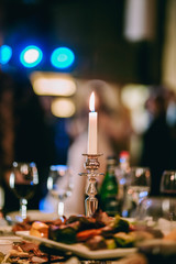 A dining table with tasty food and candle in restaurant