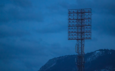 Big vintage stadium lights on a lighting tower in an off state. Evening setting with stadium lights...