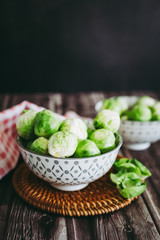 Choux de Bruxelles dans un petit bol céramique posé sur la table en bois en cuisine