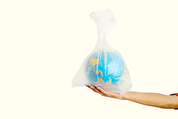 Human hand holding globe in plastic bag in studio
