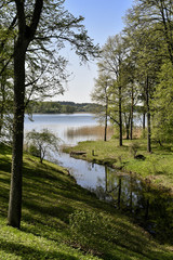 Letni, sielankowy widok na jezioro i ogród Pałacu Tyszkiewiczów w Zatroczu - dzielnicy Troków...