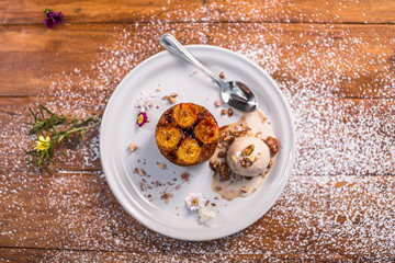 Tasty dessert banana bread whit walnut ice crema on a round white plate and sugar decoration