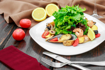 salad with seafood, with mussels and shrimps on a wooden background