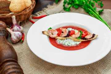 gazpacho with shrimps in a white plate