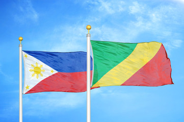 Philippines and Congo two flags on flagpoles and blue cloudy sky