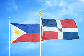 Philippines and Dominican Republic two flags on flagpoles and blue cloudy sky