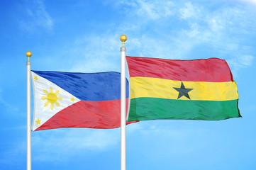 Philippines and Ghana two flags on flagpoles and blue cloudy sky