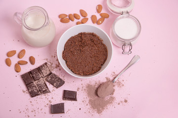 Crema de cacao vegana con ingredientes sobre fondo rosa.