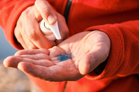 man hands using alcohol antiseptic gel in sanitizer bottle prevent infection coronavirus Covid-19 and other germs, bacteria and viruses. Closeup view