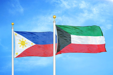 Philippines and Kuwait two flags on flagpoles and blue cloudy sky