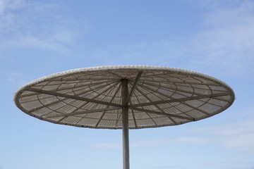 beach umbrella against the blue sky in a tropical resort. The concept of tourism and leisure and vacation. With copy space for text