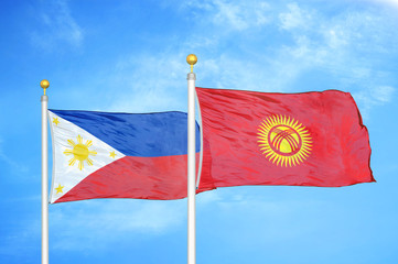 Philippines and Kyrgyzstan two flags on flagpoles and blue cloudy sky